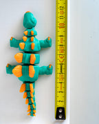 Stegosaurus figure next to measuring tape for scale