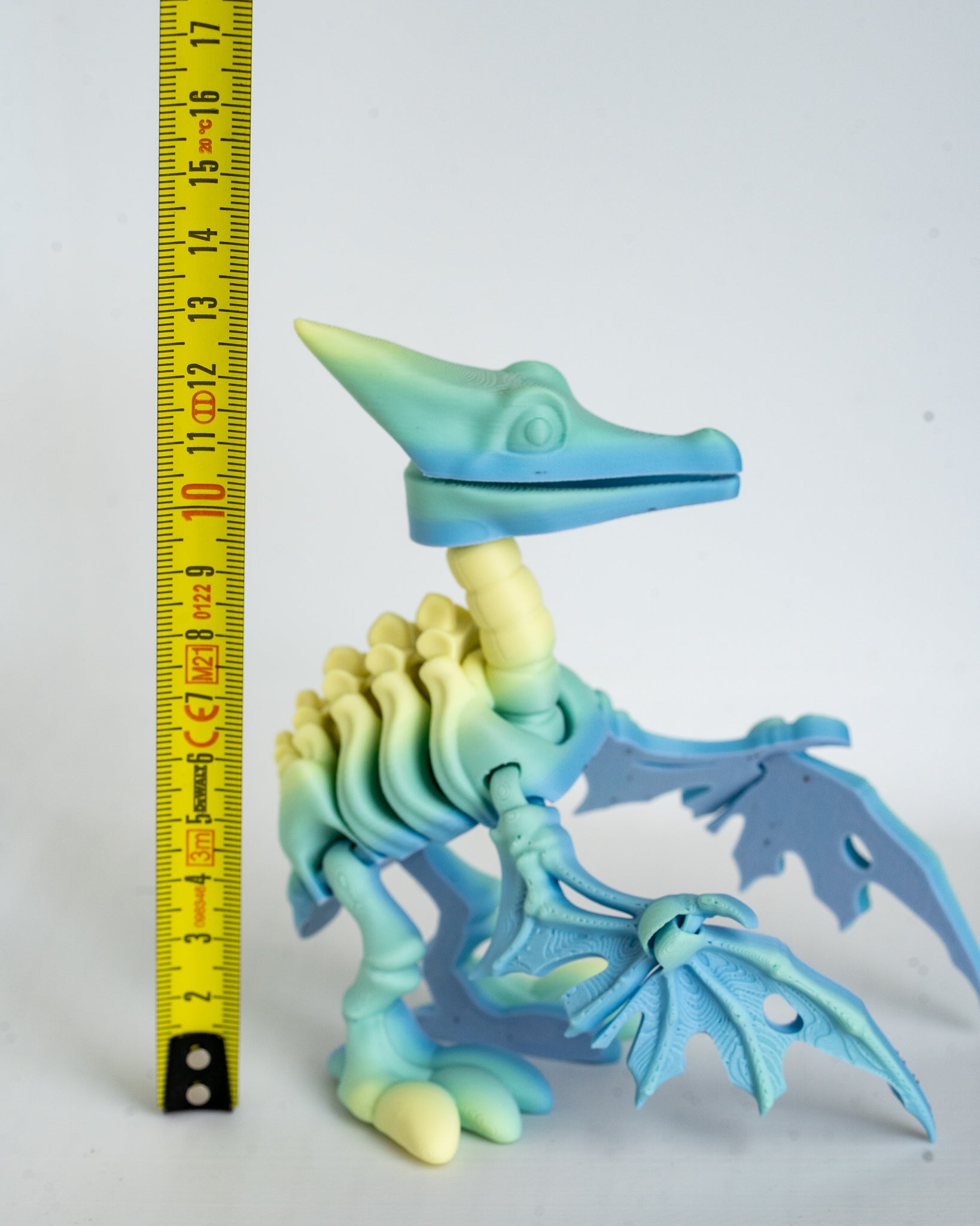 Pterodactyl skeleton figure next to measuring tape for scale