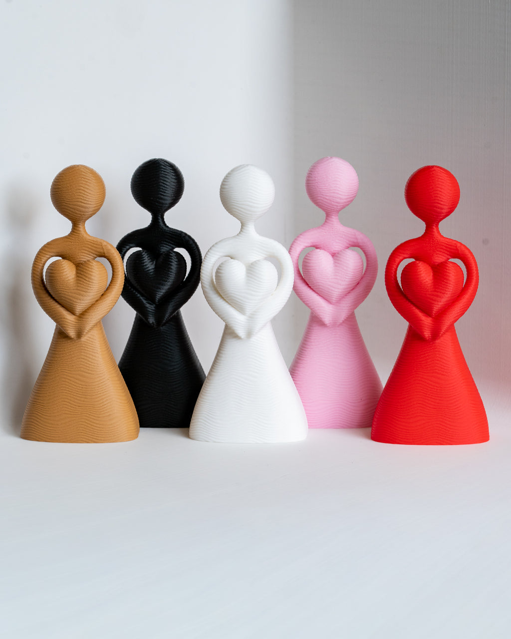 3D printed abstract couple figures in red pink white black and beige colours