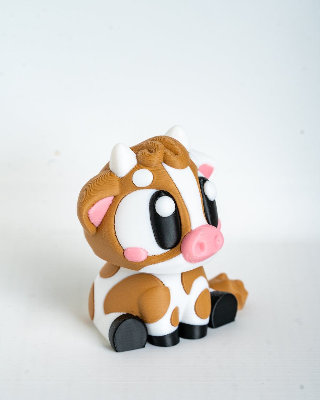 Mini cow figurine with cartoon eyes