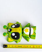 Alien cat figure next to measuring tape for scale
