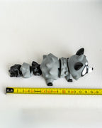 Raccoon figure next to measuring tape for scale