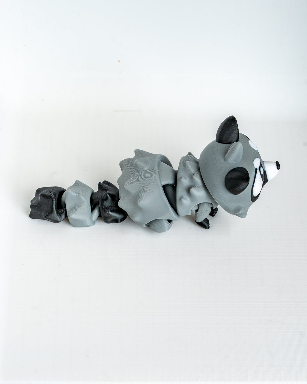 Raccoon figure lying down viewed from side