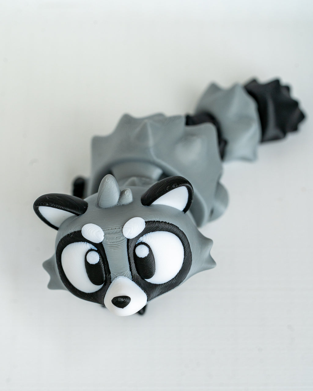 Articulated raccoon figurine with cartoon eyes