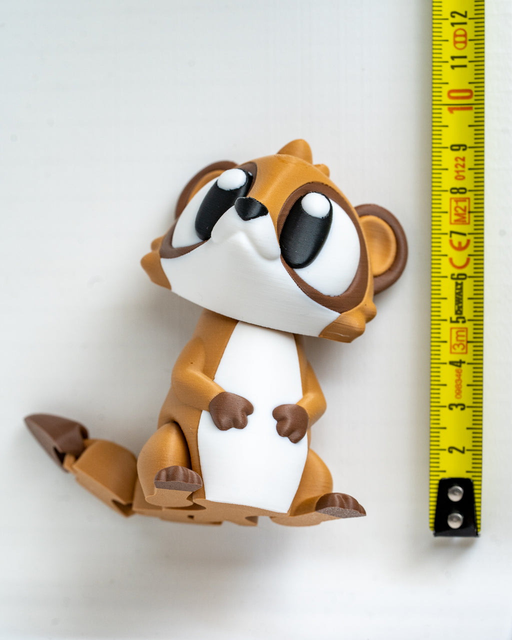 Meerkat figure next to measuring tape for scale