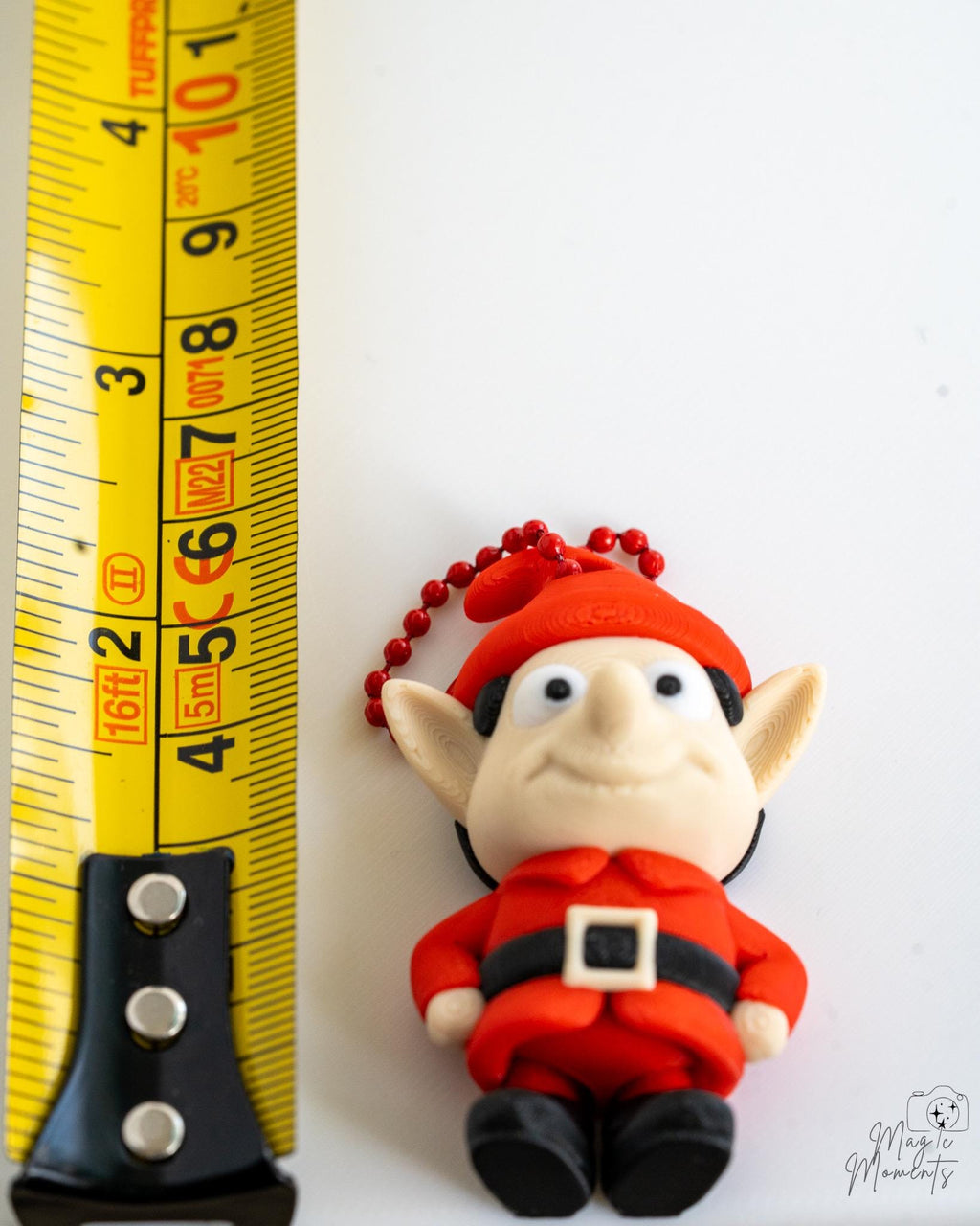 red christmas elf next to measuring tape for scale
