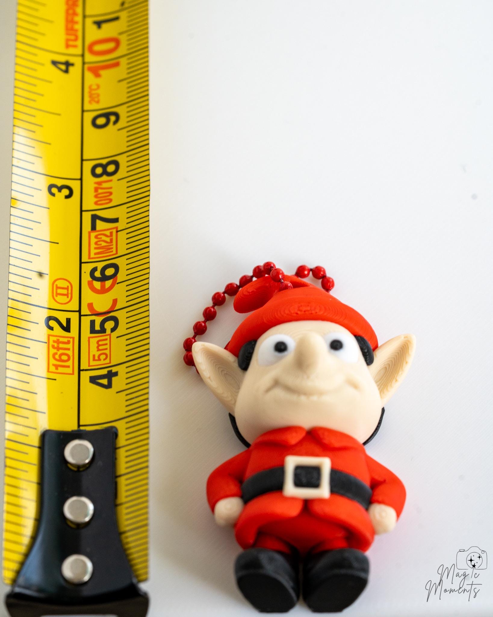 red christmas elf next to measuring tape for scale