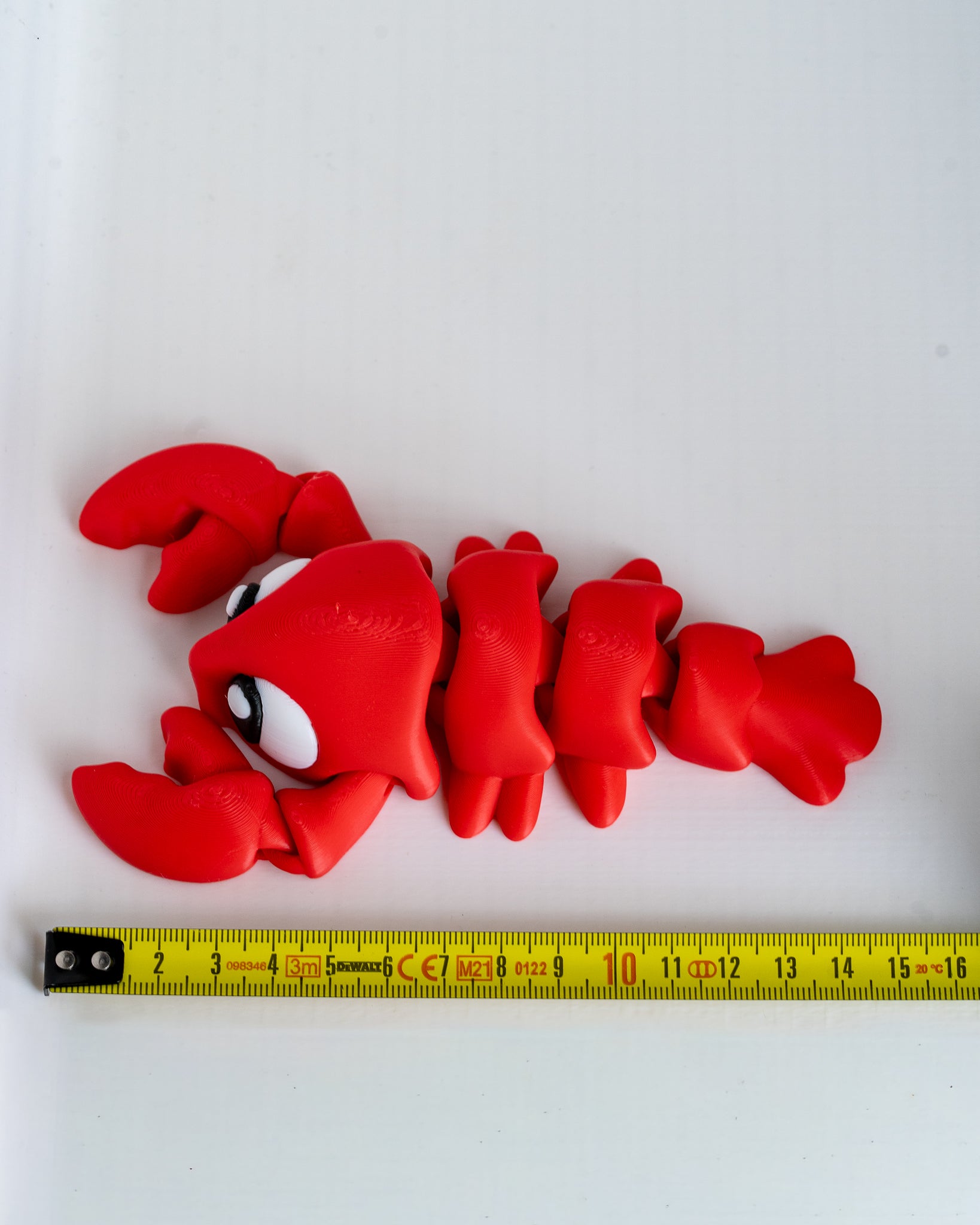Lobster figure next to measuring tape for scale