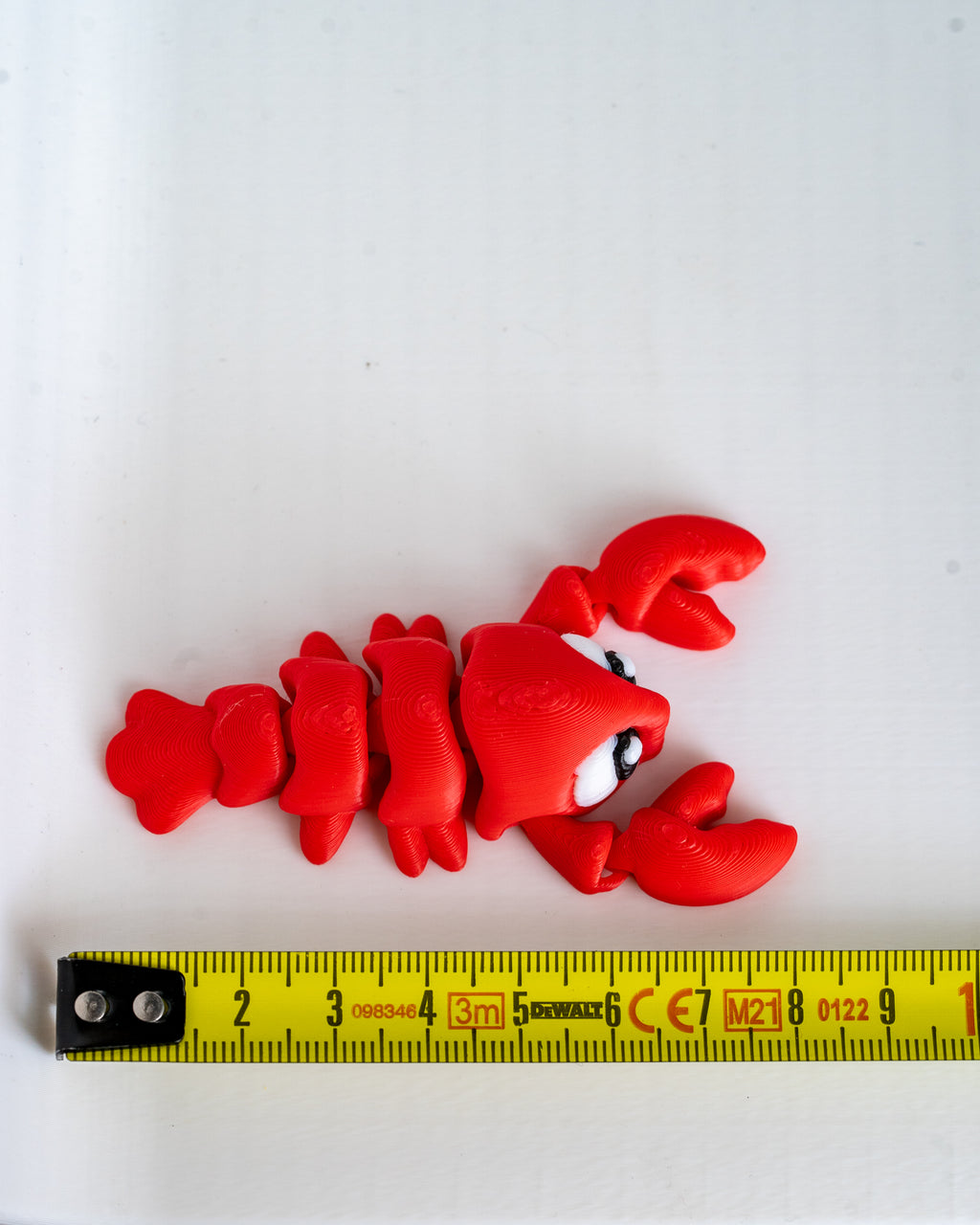 Lobster figure next to measuring tape for scale