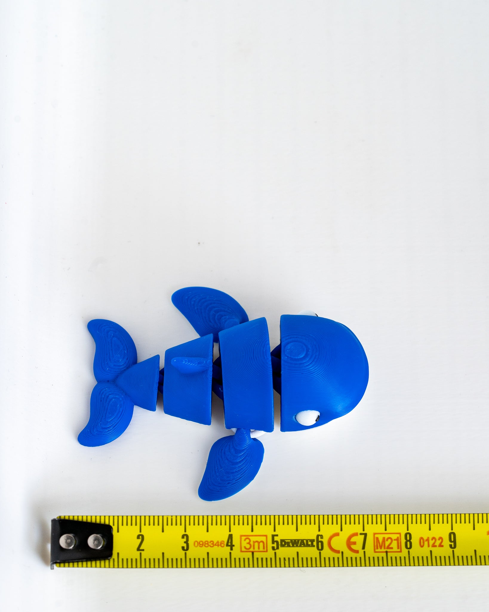 Blue whale figure next to measuring tape for scale
