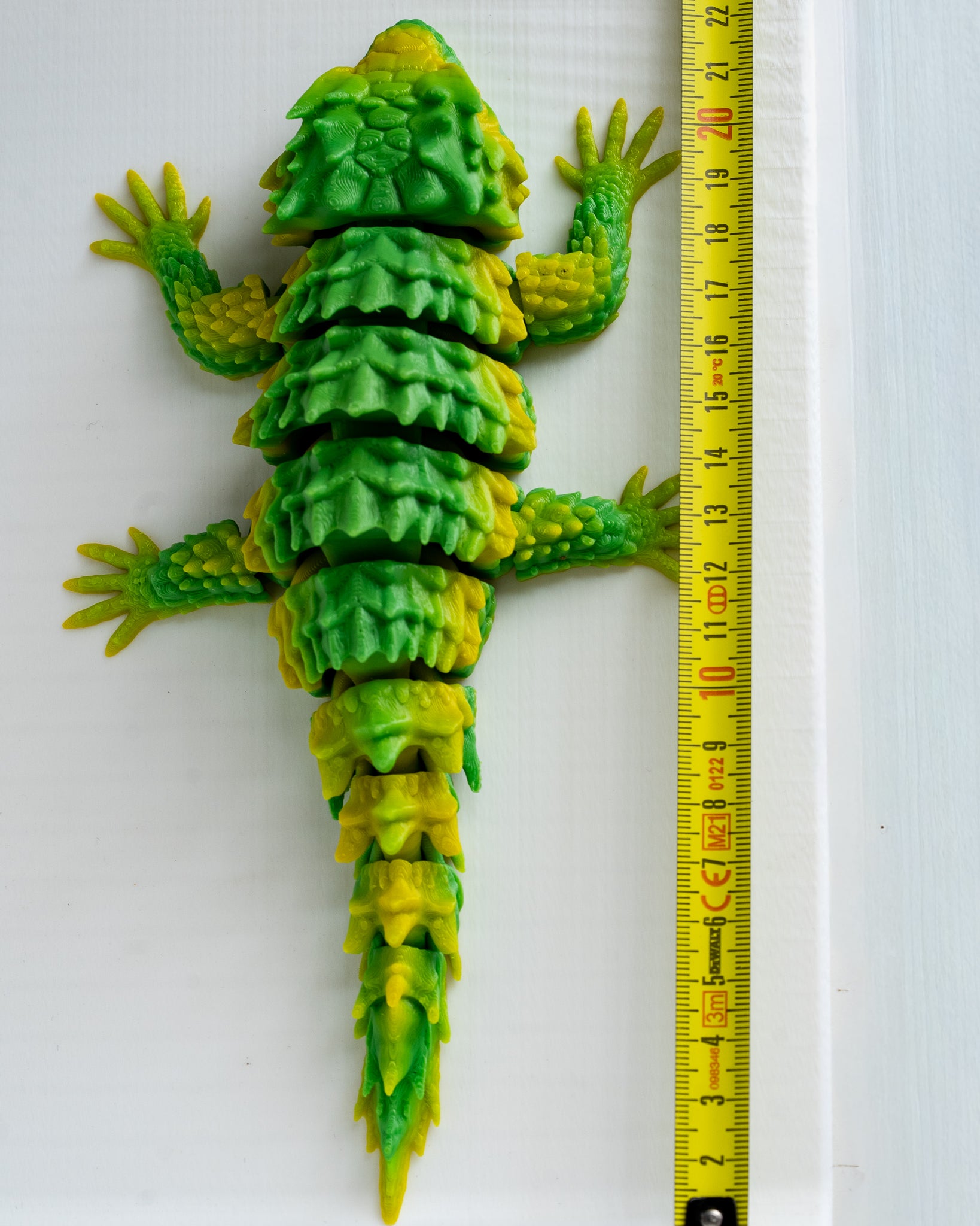 Lizard figure next to measuring tape for scale