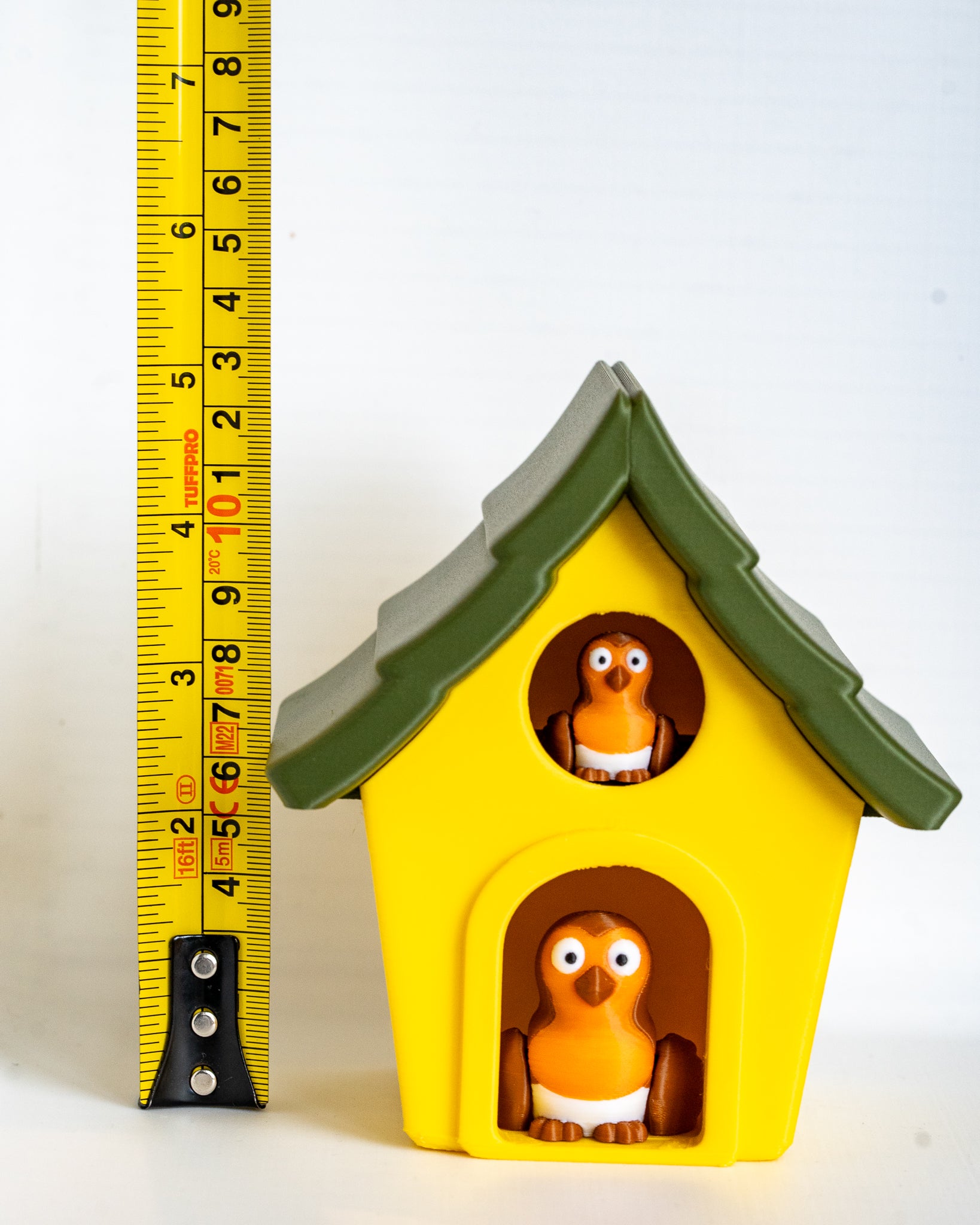 Bird house container next to measuring tape for scale