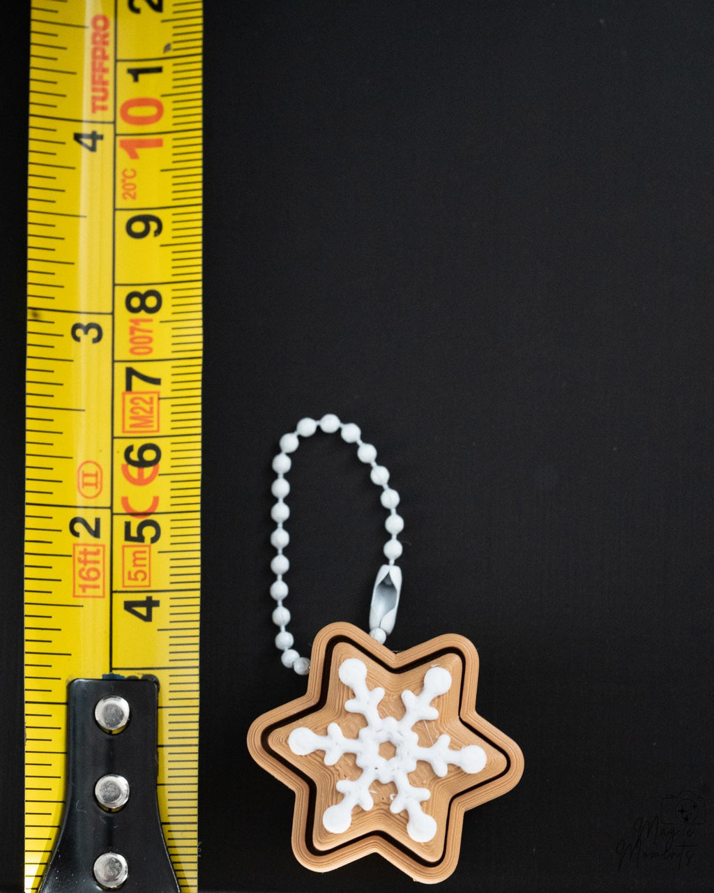 gingerbread snowflake clicker next to measuring tape for scale