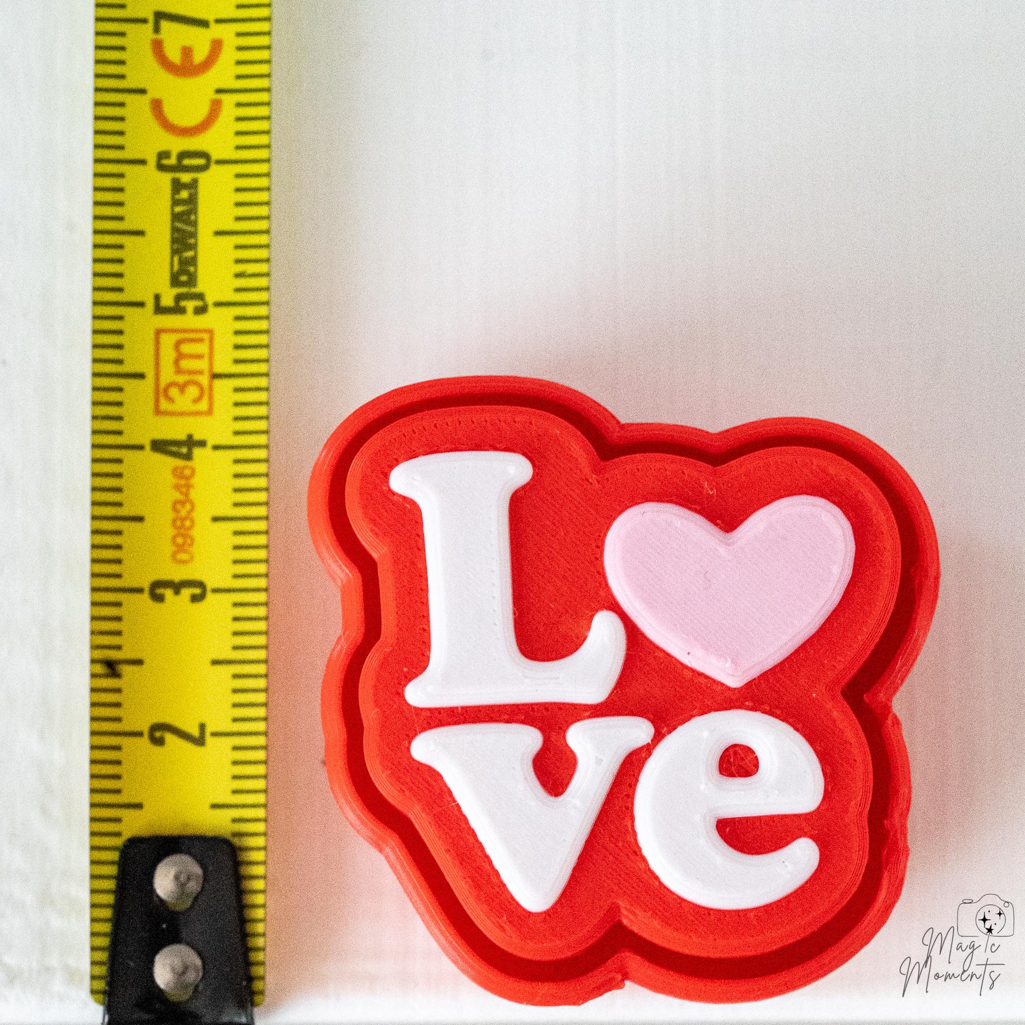 Love clicker next to measuring tape for scale