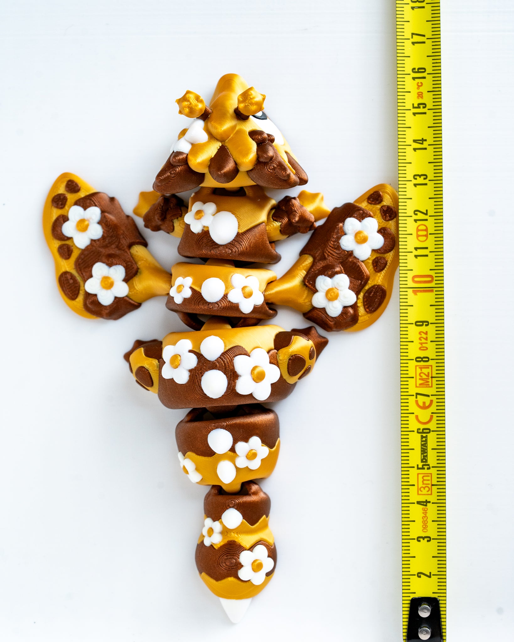 Bee dragon figure next to measuring tape for scale