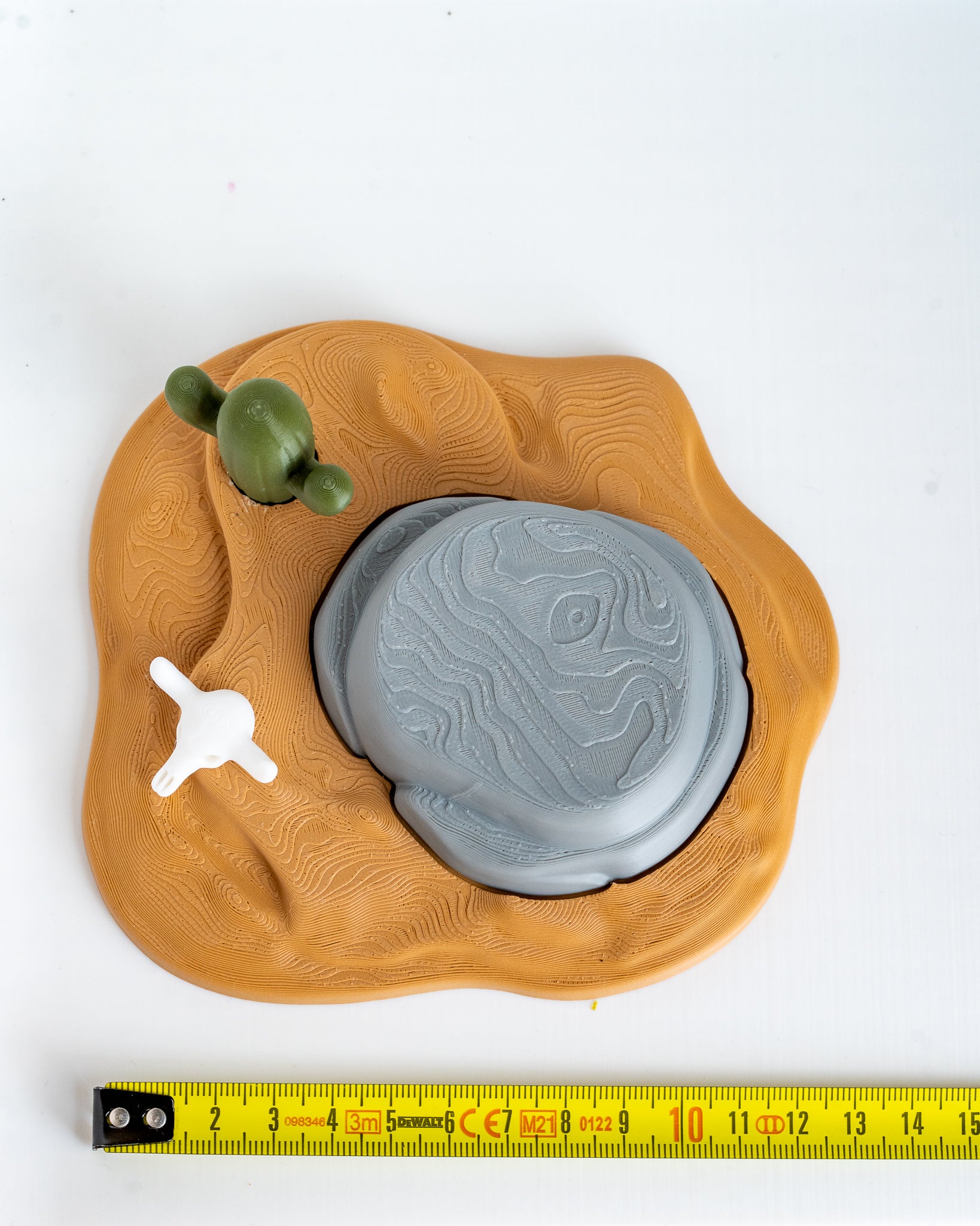 Desert scene base next to measuring tape for scale