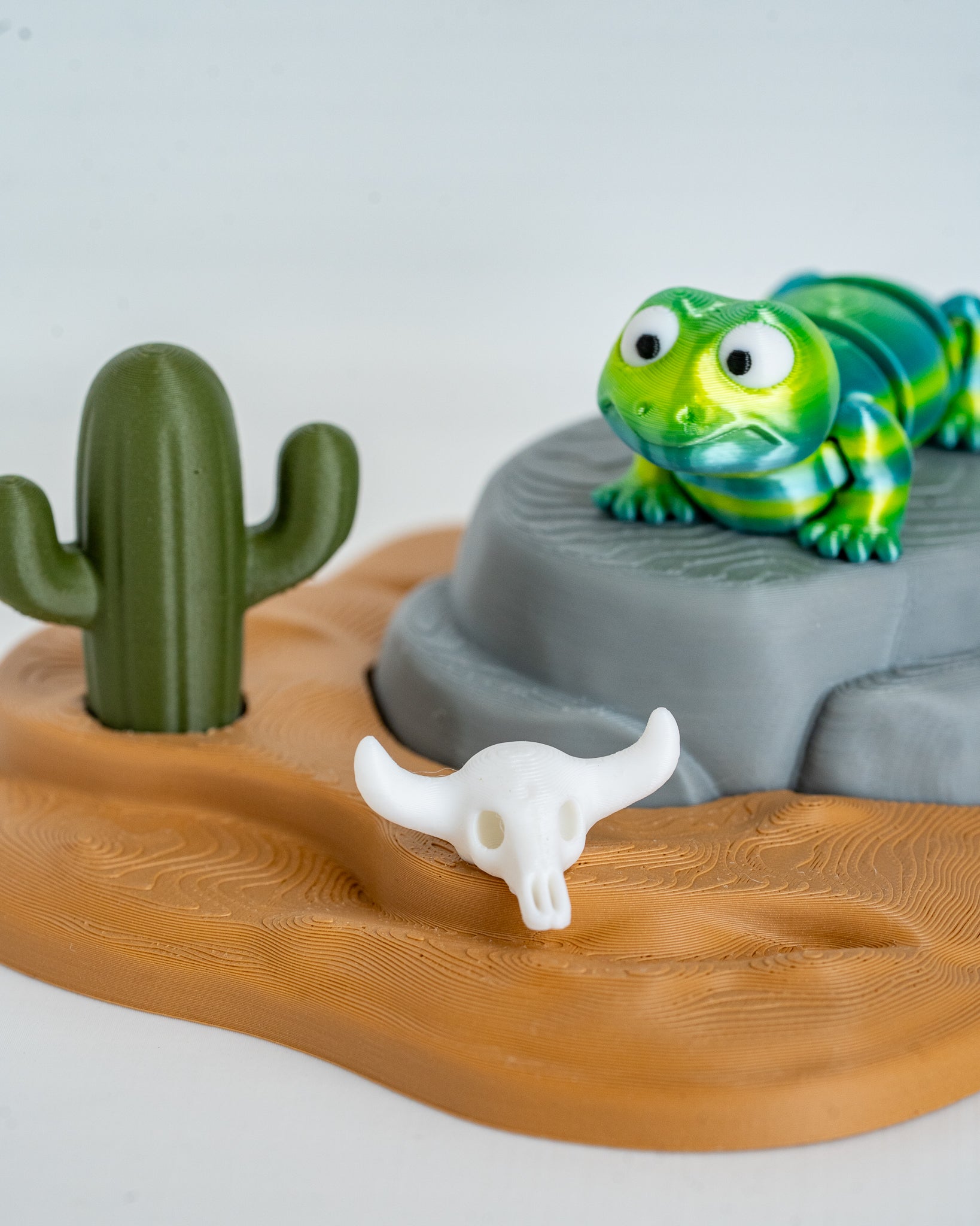 Green lizard figurine with desert display stand