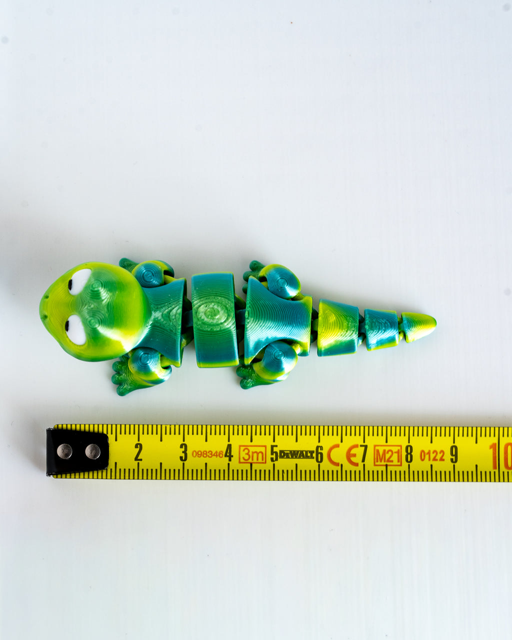 Lizard figure next to measuring tape for scale