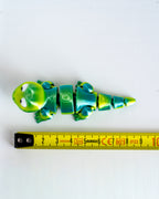 Lizard figure next to measuring tape for scale