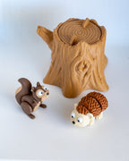 squirrel and hedgehog figurines with tree stump container