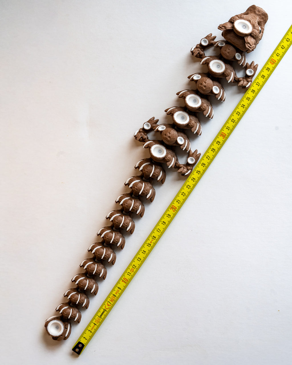 Coconut dragon figure next to measuring tape for scale
