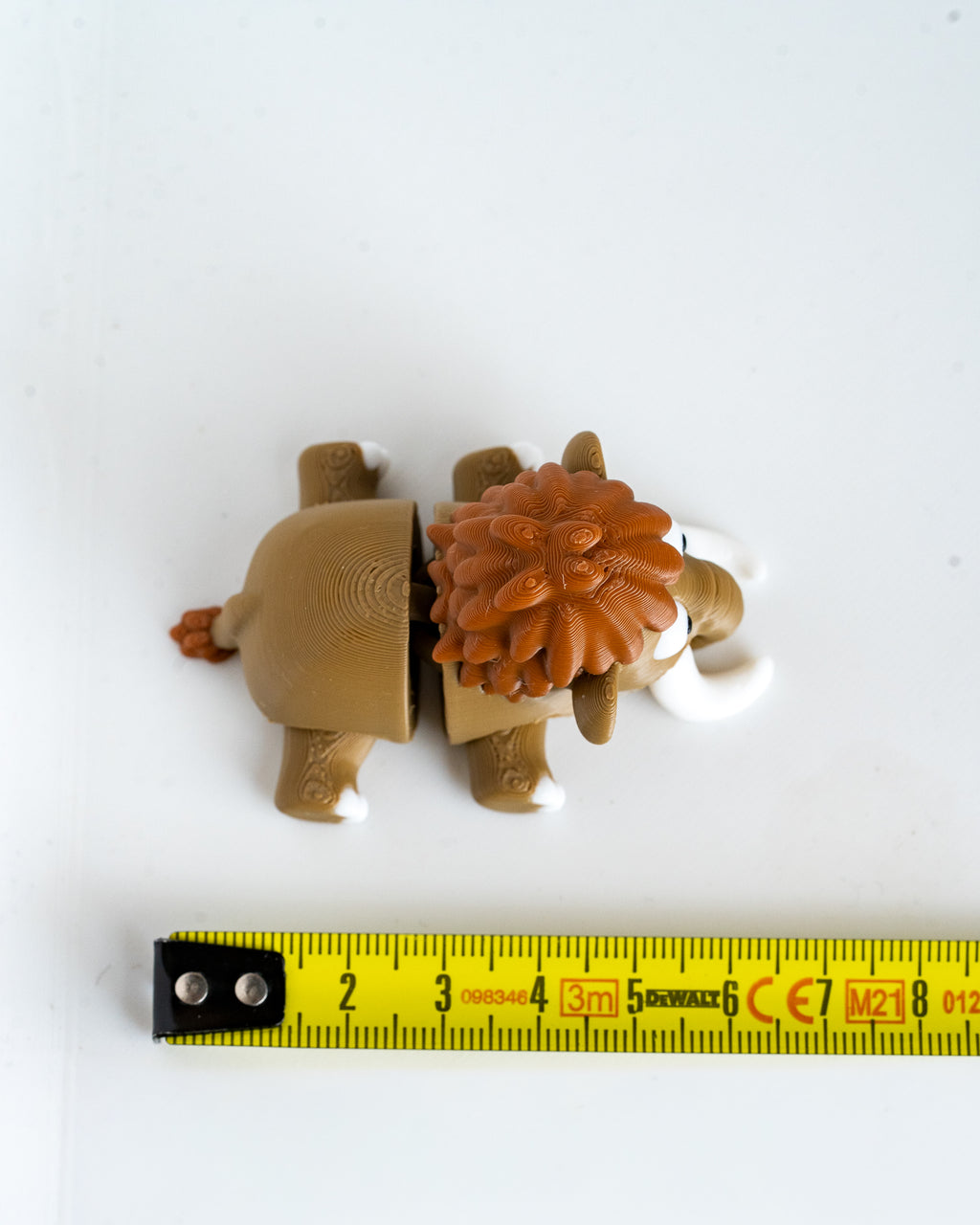 Mammoth figure next to measuring tape for scale