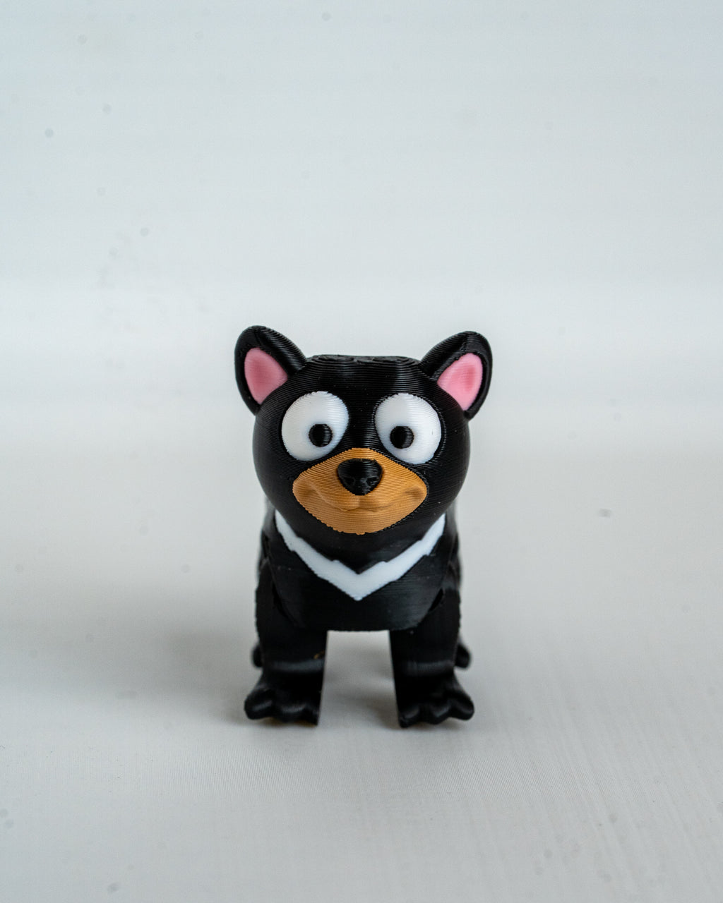 tasmanian devil figurine with pink ears and a brown nose on a white background