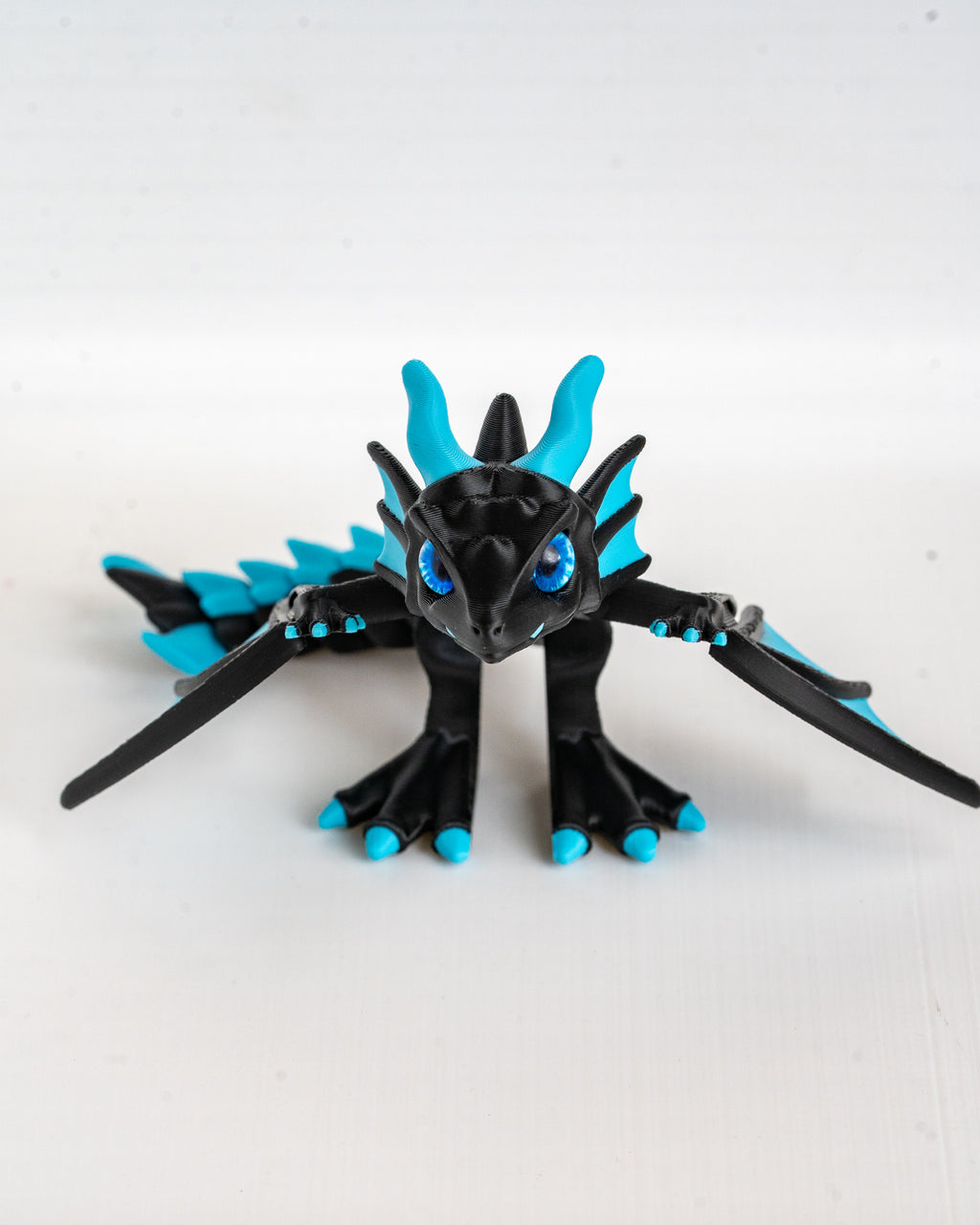Black and blue dragon figurine on a white background