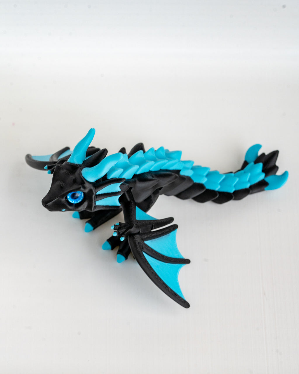 Articulated sky blue and black dragon figurine 