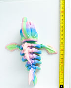 Colorful skeleton anglerfish next to a measuring tape on a white background