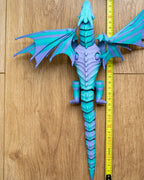 Winged dragon figure next to measuring tape for scale