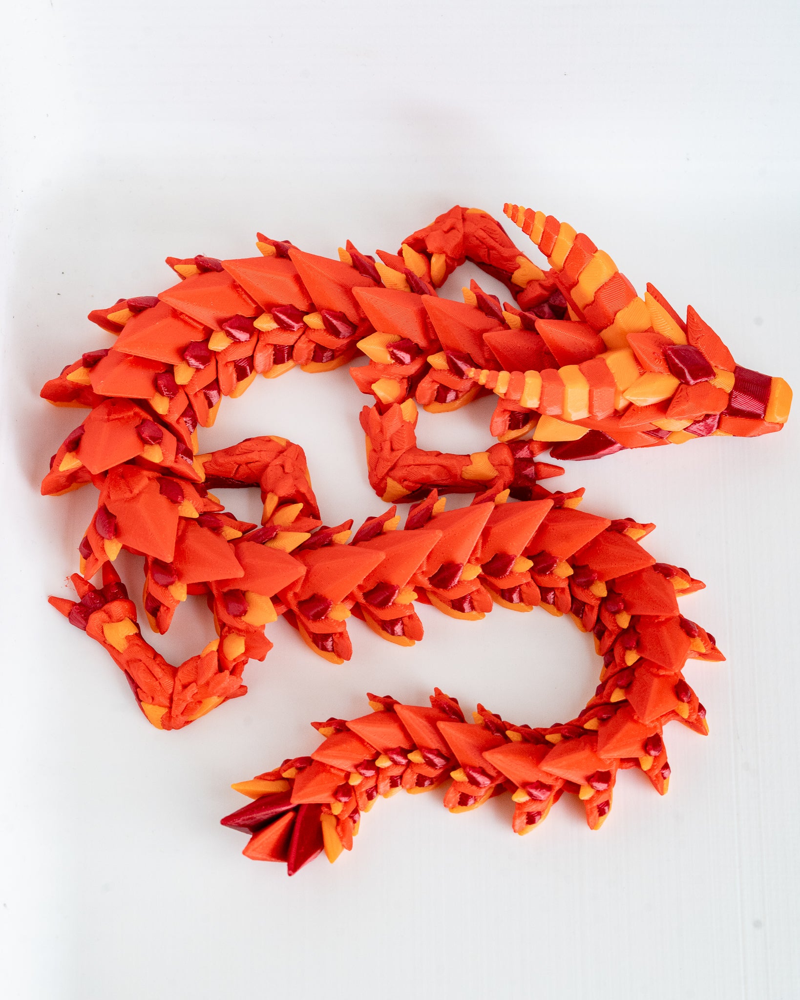 Red and orange dragon-shaped figurine on a white background