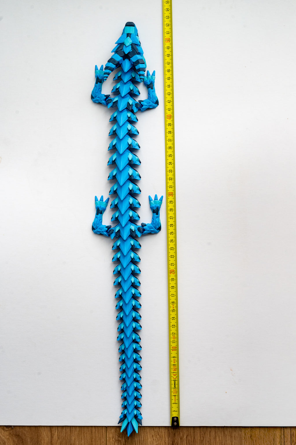 Dragon figure next to measuring tape for scale