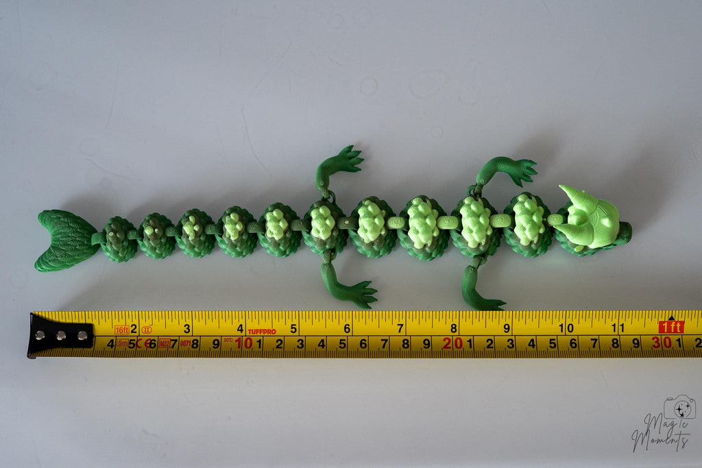Green dragon next to measuring tape for scale
