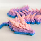 Colorful dragon with a gradient of pink, purple, and blue on a white background.
