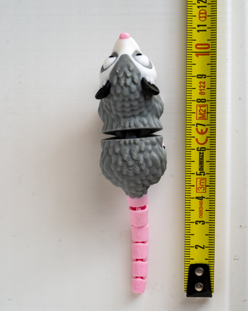 Possum figure next to measuring tape for scale