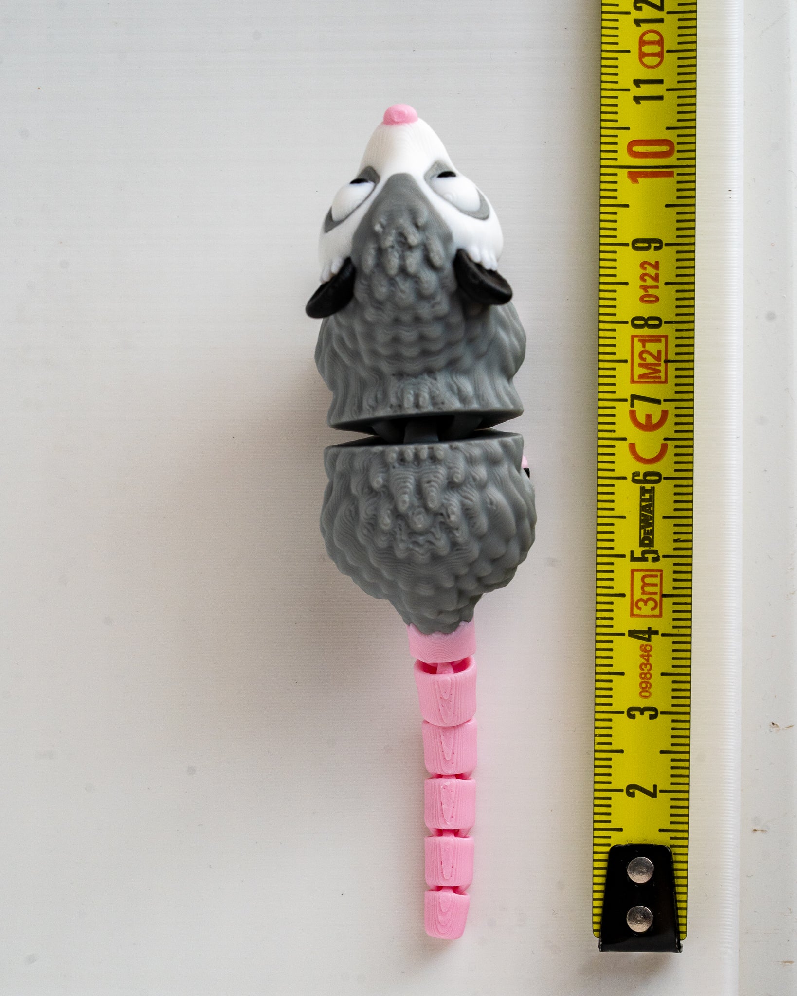 Possum figure next to measuring tape for scale