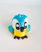 Toy figure of a blue and yellow bird on a white background
