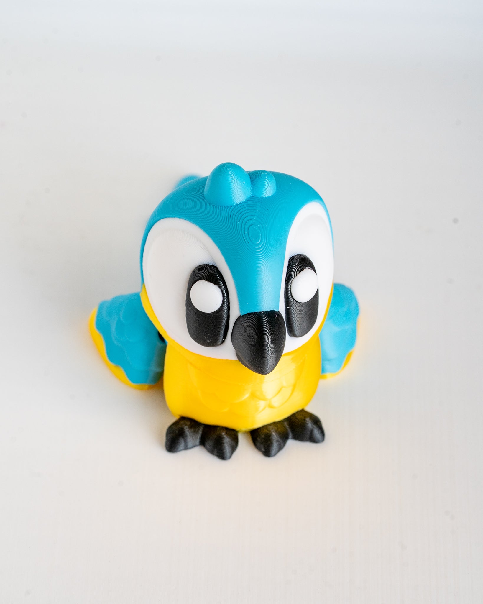 Toy figure of a blue and yellow bird on a white background