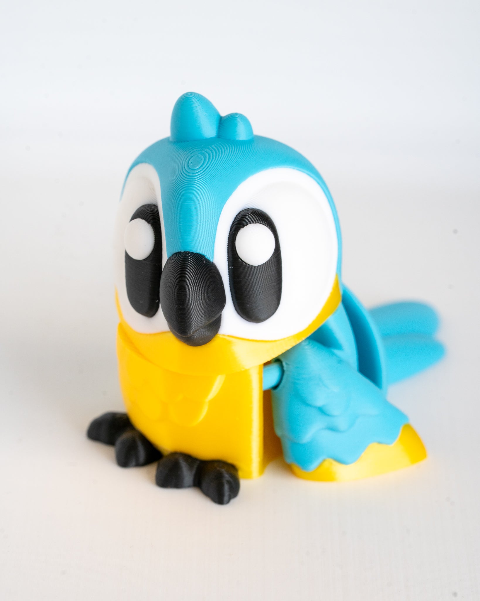blue and yellow parrot figure on a white background