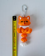 fox keychain next to measuring tape for a scale