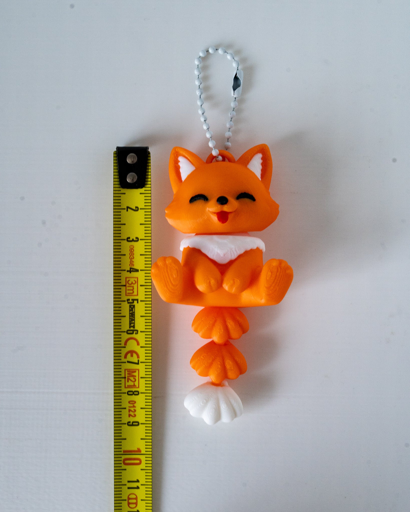 fox keychain next to measuring tape for a scale