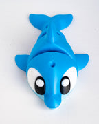 A bright blue dolphin-shaped plastic toy with large white eyes and black pupils, photographed on a plain light background.