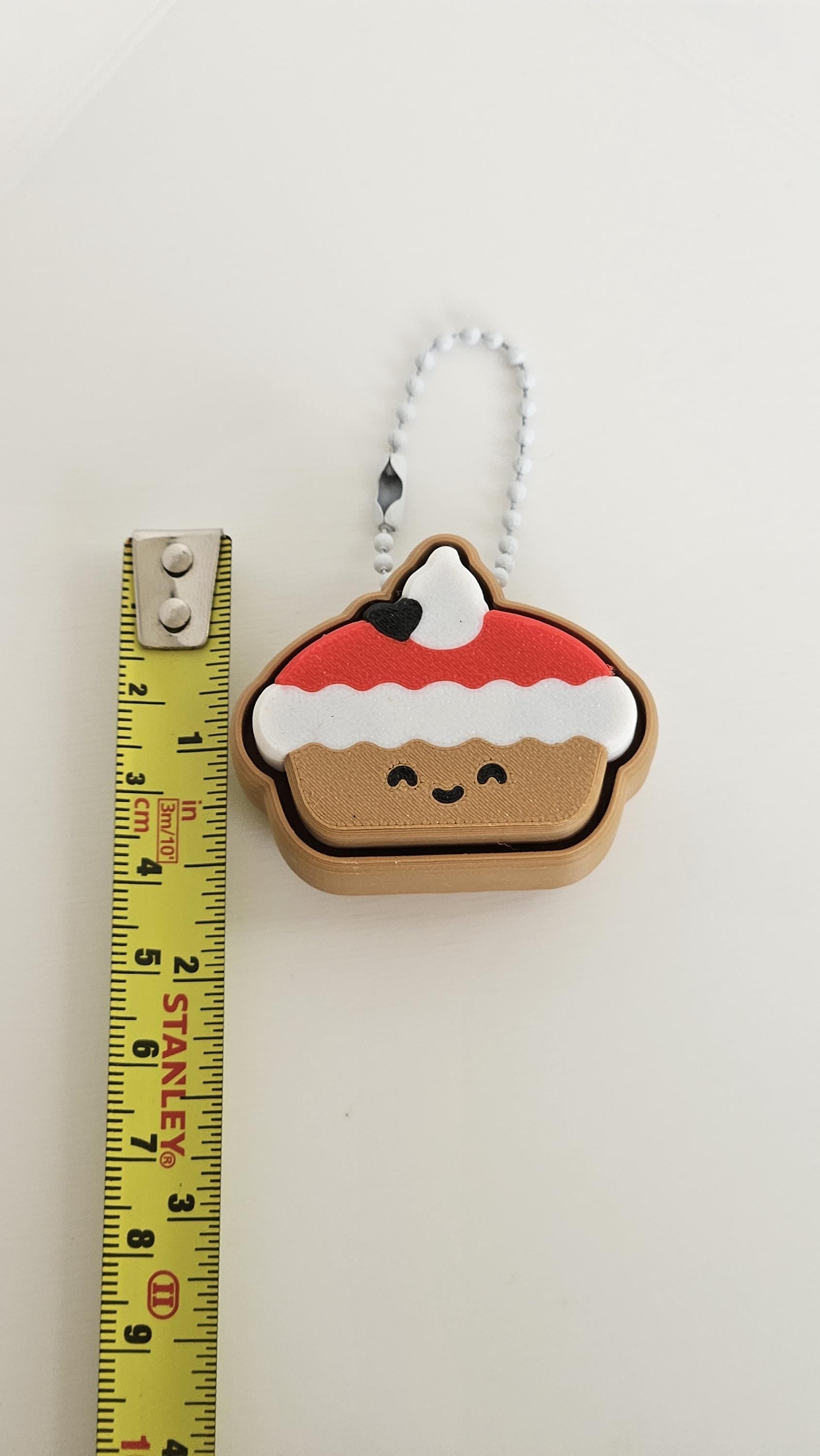 christmas pudding clicker next to measuring tape for scale