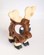 A small moose figurine with a brown body, large cream-colored antlers, white and black eyes, and black hooves, standing on a plain light background.
