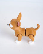 A small articulated dog toy in tan and white with a pink inner ear, photographed on a plain white background.
