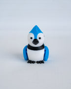 A small blue joy figurine with black accents, standing against a plain light gray background.