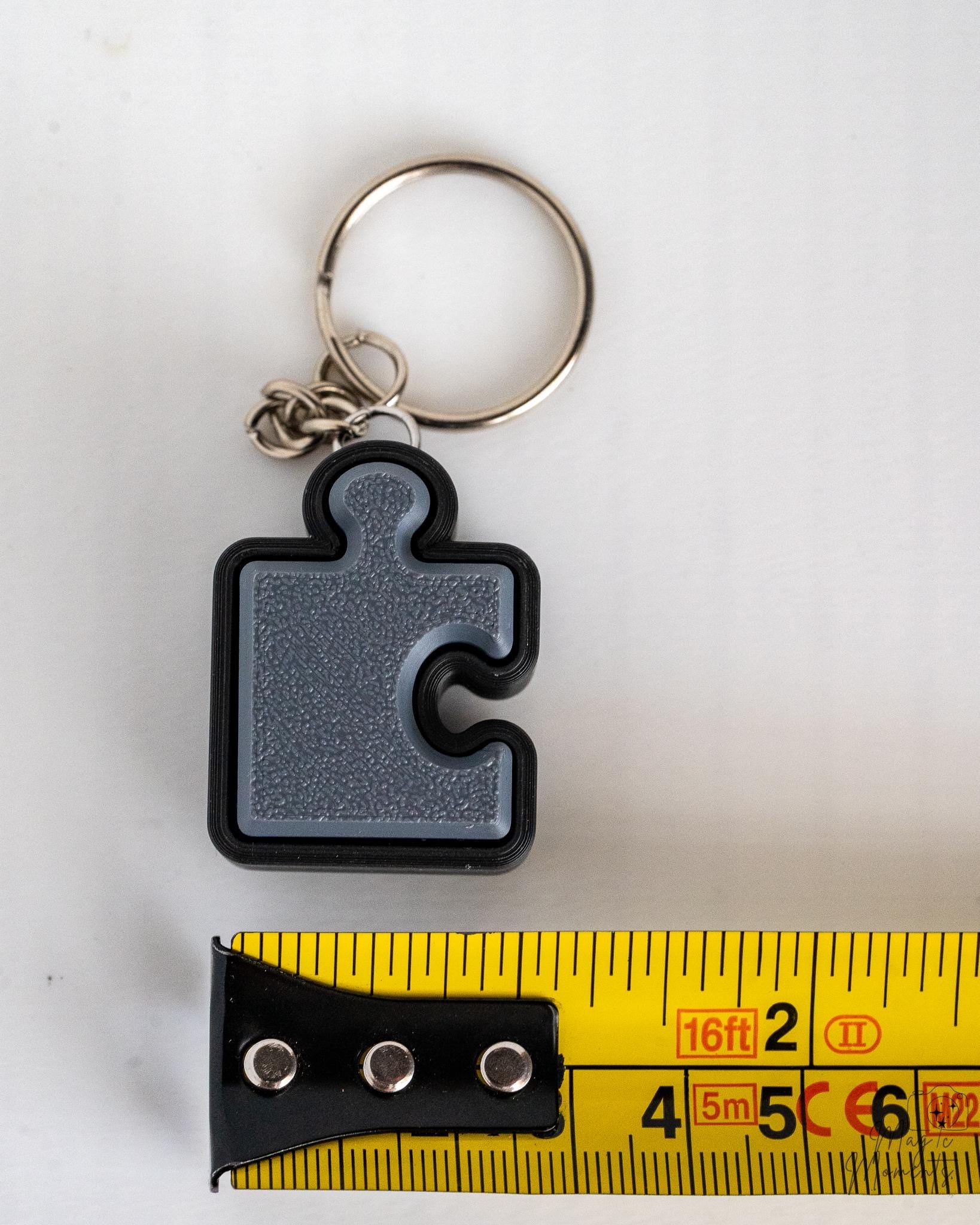 grey puzzle piece clicker keychain