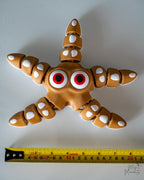 3D printed articulated starfish next to measuring tape