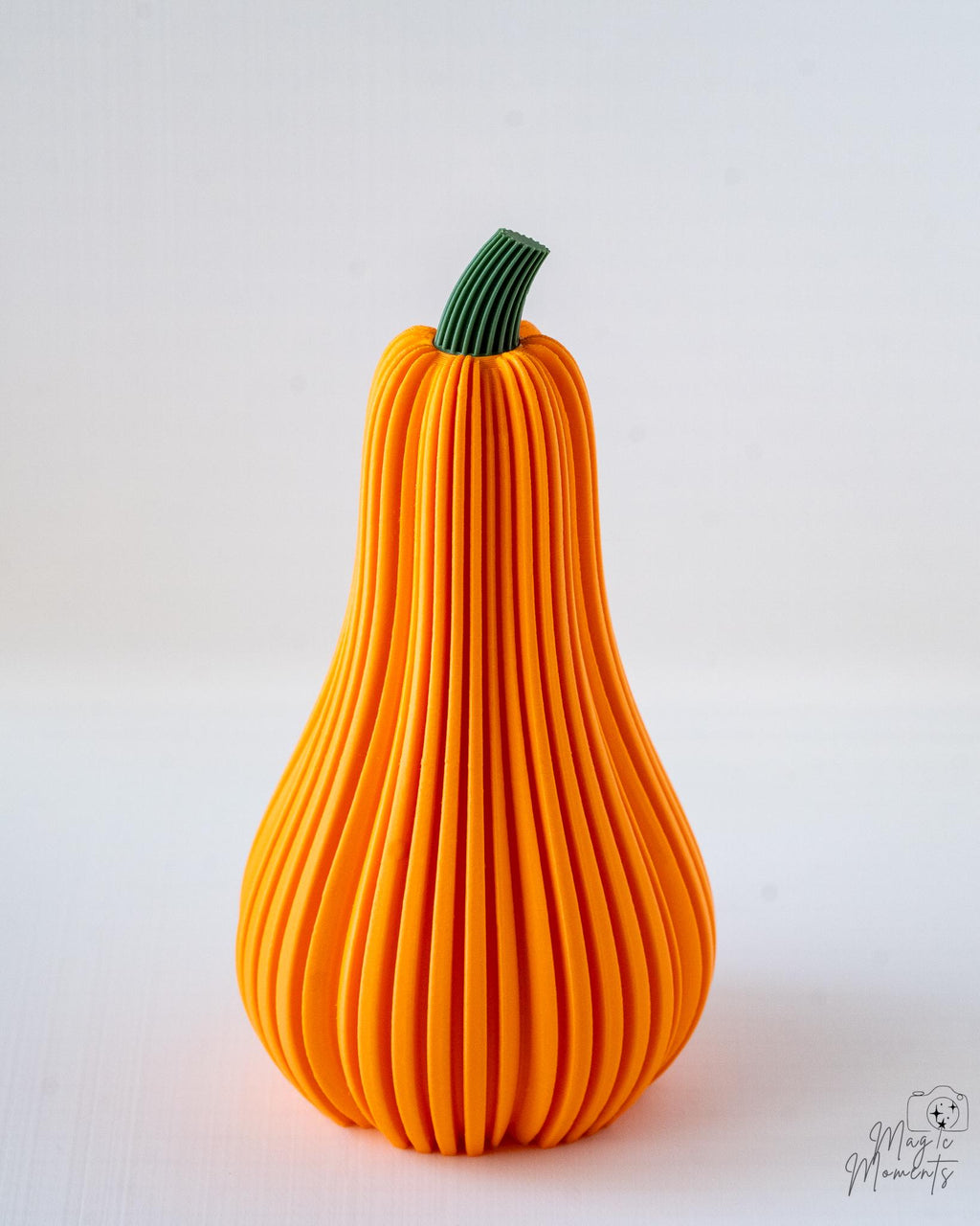 Orange decorative gourd with a green stem on a white background